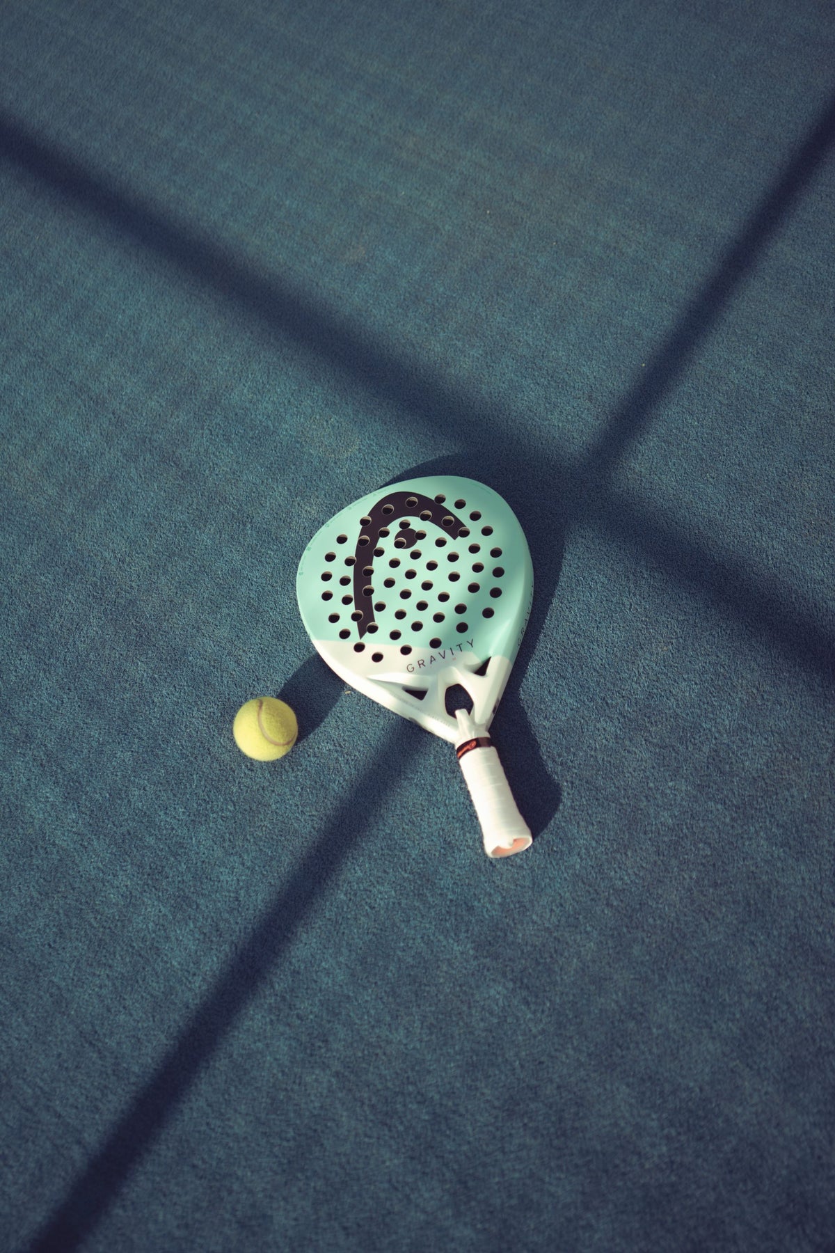 Racchetta da padel e pallina al sole
